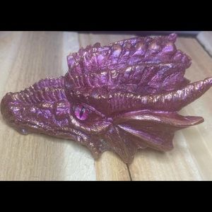 I am selling a dragon head. It is a pink/purple color, and has a gold affect.